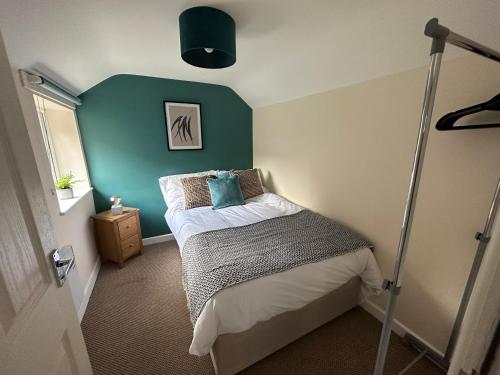 LincolnshireNumber 3 Seafield - sleeps 4 - Grantham town的一间卧室配有一张带绿色墙壁的床