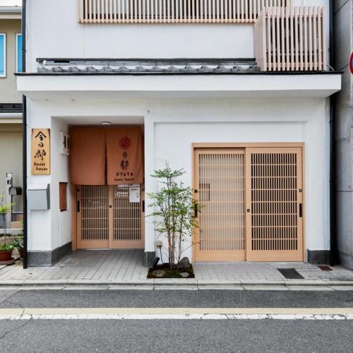 京都Kyoto Hostel japanese room 2F / Vacation STAY 8178的两扇门的建筑,前面有一棵树