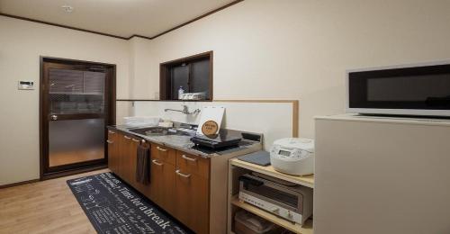 京都Kyoto Hostel japanese room 2F / Vacation STAY 8178的带冰箱的小厨房和电视。