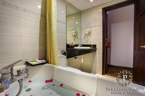 河内Parklane Central Hanoi Hotel的浴室配有白色浴缸和水槽