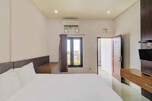 登巴萨OYO 92315 Prostay Bali的卧室设有一张白色大床和一扇窗户。