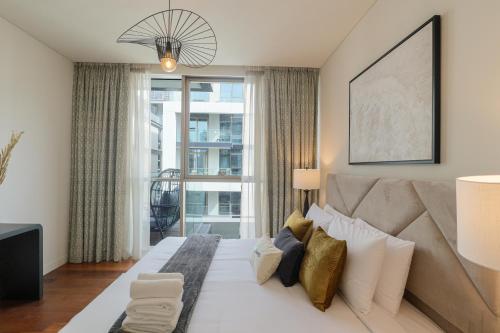 迪拜HiGuests - Charming Retreat in CityWalk With Balcony and Pool的一间卧室设有一张大床和一个大窗户