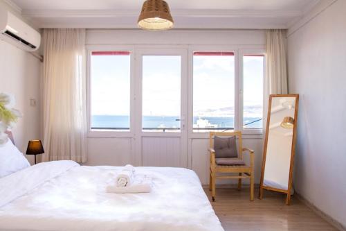 伊兹密尔Lovely House with Sea View and Backyard的一间卧室配有一张床、一把椅子和窗户。