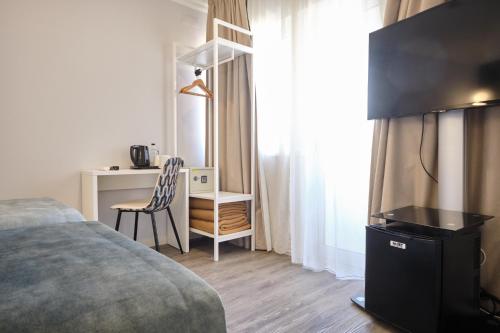 里斯本帕特里亚酒店的一间卧室配有一张床和一张桌子及椅子