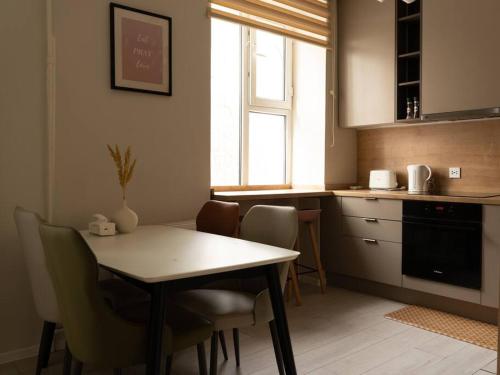 乌兰巴托Cozy two bedroom in heart of UB的厨房配有桌椅和窗户。