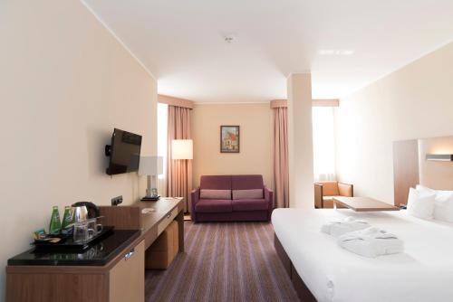 波兹南波兹南德席尔瓦高级酒店的酒店客房,配有床和沙发