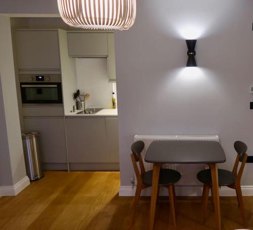 特威克纳姆Stylish Studio Apartment, ensuite, kitchenette的厨房配有桌子、两把椅子和台面