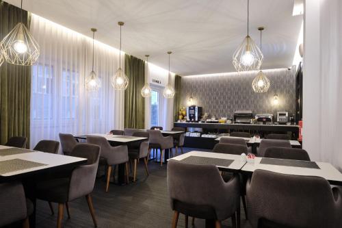里斯本Duplo Charme Boutique Hotel的一间带桌椅和灯光的餐厅