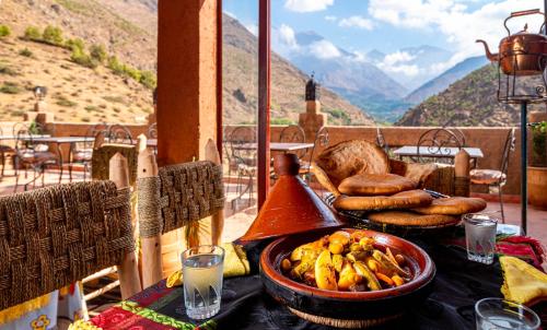 伊姆利尔Atlas Kasbah Lodge的阳台上摆放着一碗香蕉和面包的桌子