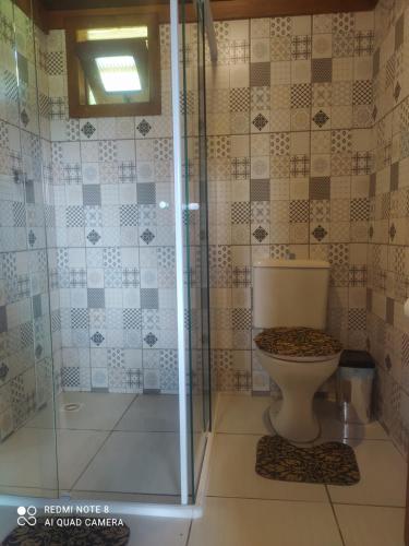 LontrasVila Sol Cabana的一间带卫生间和玻璃淋浴间的浴室