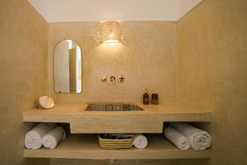 马拉喀什Riad Rahal的浴室配有盥洗盆、镜子和毛巾