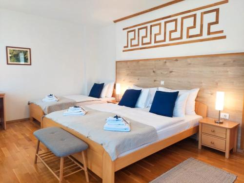 普利特维采湖Plitvice Lower Lakes Rooms的一间卧室配有两张带蓝白色枕头的床