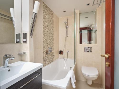 伦敦The Prime London Hotel的带浴缸、卫生间和盥洗盆的浴室