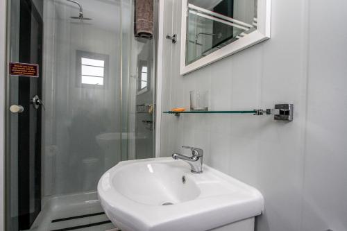 MatoksSleepOver Matoks的白色的浴室设有水槽和淋浴。