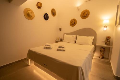 卡特瑞杜斯Acrus Villa Santorini with Heated pool的卧室配有一张大白色床,墙上挂有盘子