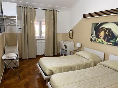 弗拉斯卡蒂维拉吉奥住宿加早餐旅馆的一间卧室设有两张床,墙上挂着一幅画
