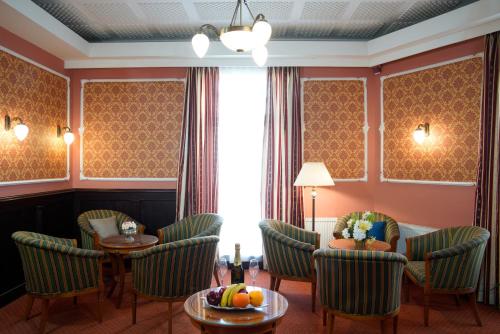 卡罗维发利Hotel Villa Lauretta的酒店客房带椅子和桌子,还有水果