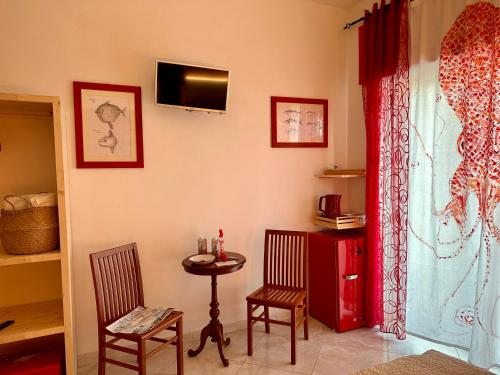 格拉齐Casa del Palombaro的配有桌子和两把椅子以及电视的房间