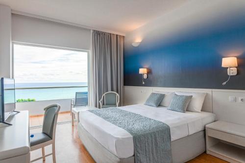 法里拉基蓝色海滩度假酒店的酒店客房设有一张床和一个大窗户