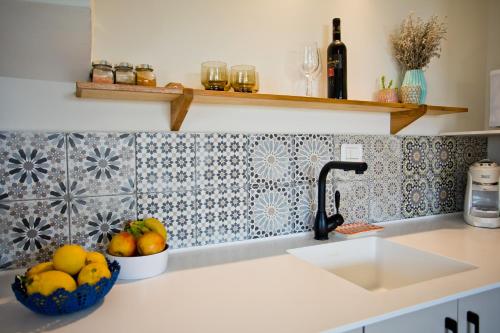 哈德拉lotus beach house的厨房柜台设有水槽和一碗水果