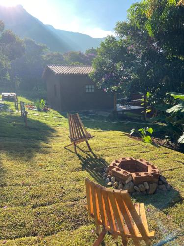 韦尔卡鲍Chalés Vila Do Vale的两个长椅坐在一个有火坑的院子内