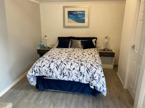 AllesleyGarden lodge的一间卧室配有一张带蓝色和白色棉被的床