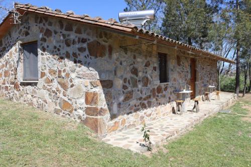 凡道Holiday Accommodation, Serra da Estrela - Casa Cabeço do Barragão的一座石头建筑,外面坐落着猫