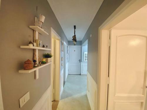 十月六日城Cozy Apartment (JANNA)的墙上有白色门和架子的走廊