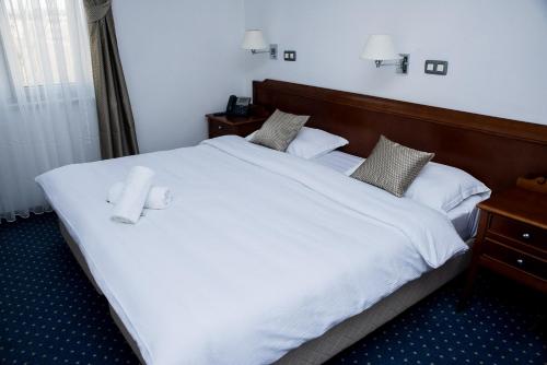 柳布什基哈姆酒店的卧室配有一张白色大床和两条毛巾