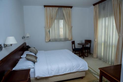 柳布什基哈姆酒店的卧室配有一张床和一张桌子及椅子