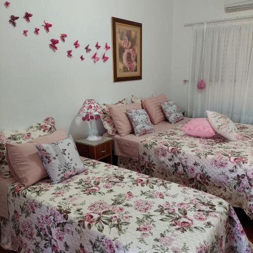 阿瓜斯-迪圣佩德罗Recanto Panapaná - suítes的墙上有蝴蝶的房间的两张床