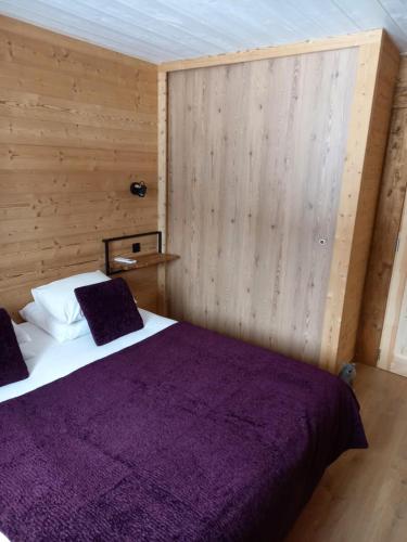 丰罗穆Eco-Logis des Cabris的一间卧室配有一张带紫色毯子的床