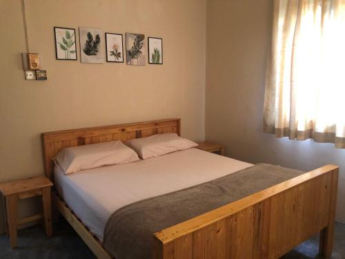 哥打巴鲁Little Cozy Homestay的一间卧室设有一张木床和一个窗户。
