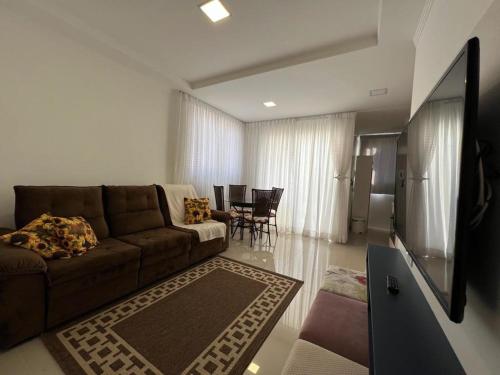 伊塔佩马Apartamento Novo e Confortável的客厅配有棕色沙发和电视
