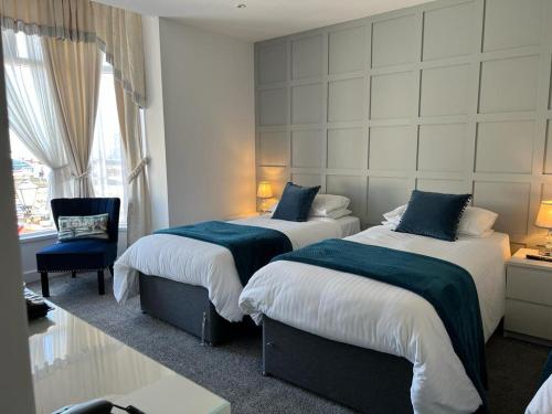 布里德灵顿雷夫尔斯托克酒店的酒店客房,配有两张床和椅子