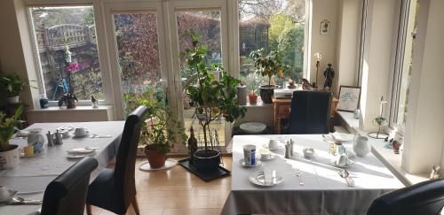 锡豪西斯Ugiebrae House Bed & Breakfast的用餐室设有2张桌子和椅子以及窗户。