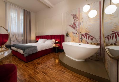 佛罗伦萨Ricasoli Garden Relais的一间卧室配有一张大床和一个浴缸