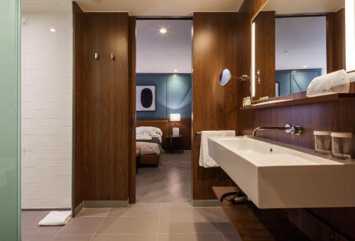 波尔图波尔图文奇酒店的一间带水槽的浴室和一张位于客房内的床