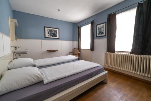 温特图尔阿尔巴尼酒店的一间卧室设有两张床,拥有蓝色的墙壁。