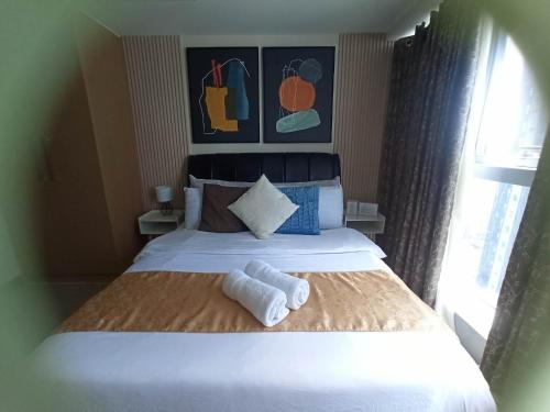 马尼拉Uptown Parksuites Tower 1 BGC的酒店客房,配有带毛巾的床