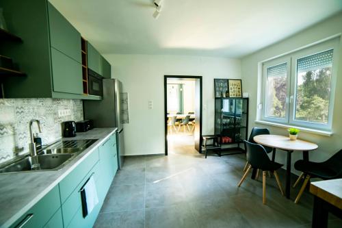 福纽德Kégli_Fonyód的厨房配有绿色橱柜和桌椅