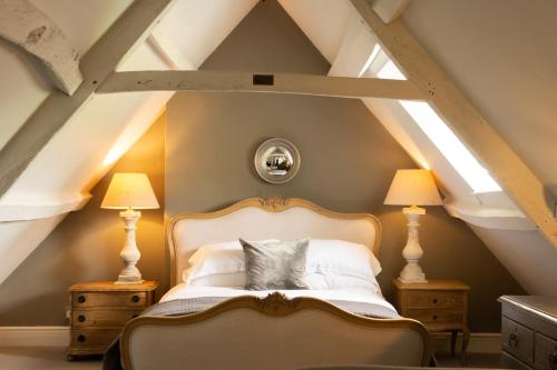 Coln Saint Aldwyn力推考林新酒店的一间位于阁楼的卧室,配有一张床和两盏灯。