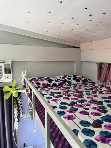 UrdanetaJC Unit #8的一间卧室配有一张紫色和蓝色鲜花的床