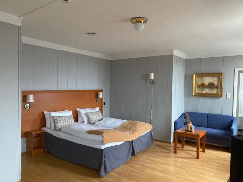 霍尔滕Horten Budget Hotel的一间卧室配有一张床和一张蓝色的沙发