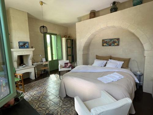 萨维勒特里Boutique Hotel Masseria Sottomasi的卧室配有一张白色大床和一把椅子