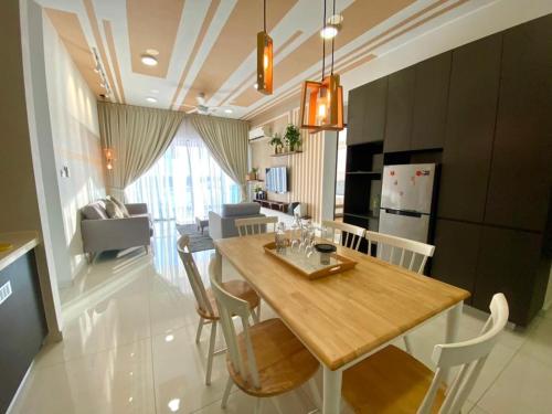 新山Royal Strand Danga Bay Abang Payung的厨房以及带木桌和椅子的用餐室。