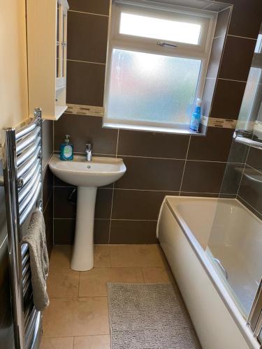 曼彻斯特Greenwood的浴室配有盥洗盆、浴缸和盥洗盆