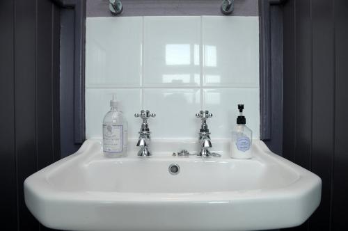 Ballydavid利艾斯卡住宿加早餐旅馆的浴室水槽配有2瓶肥皂和窗户