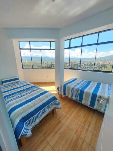 阿亚库乔Disha's Home Casa Hospedaje的带大窗户的客房内的两张床