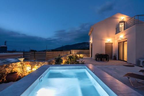 Agios PadeleimonPink Sand Villas的夜间屋顶的游泳池